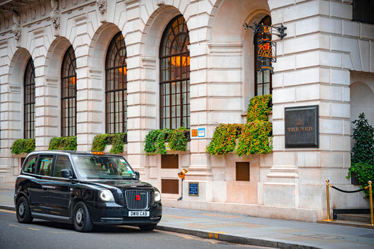 The Ned Luxury Hotel Sign, Logo, British Black Cab Taxi (Hackney Carriage Car Front), City Of London, Poultry, England, United Kingdom &mdash; 17 November 2025
