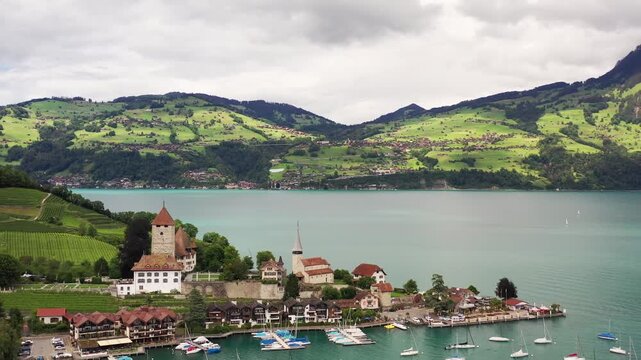 Aerial view of iseltwald castle and church by the turquoise lake, nestled against rolling green hills, captivating the serene beauty, iseltwald, Canton of Bern, Switzerland.