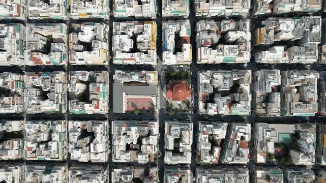Aerial view of the city's buildings, with various shades of white and grey, and a church with a red dome, Athens, Central Athens Regional Unit, Greece.