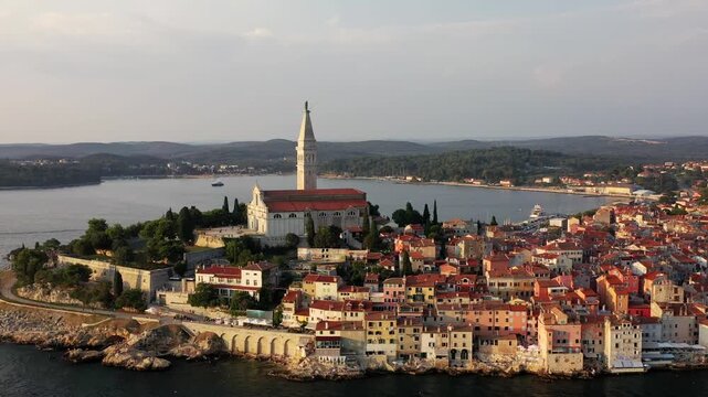 Aerial view of the striking Church of St. Euphemia standing tall, with terracotta rooftops cascading down to the Adriatic sea, Rovinj, istria County, Croatia.