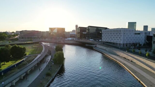 Aerial view of the Spree River reflecting sunlight near modern buildings and walkways with central station, creating a vibrant urban scene, Berlin, Germany.