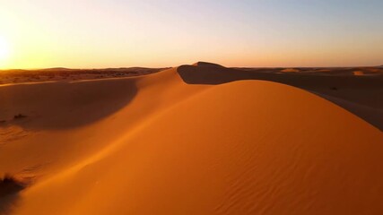 Dynamic interplay of golden light and deep shadows across undulating sand formations, highlighting the desert's ever changing textures at dawn. Capturing the serene yet powerful essence of a?