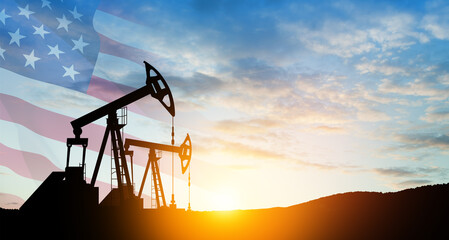 The change in oil prices caused by the war. Oil price cap concept. Oil drilling derricks at desert oilfield with USA flag. Crude oil production from the ground. Petroleum production.