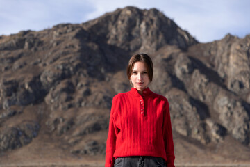 Portrait of woman in red stands proud with mountain background