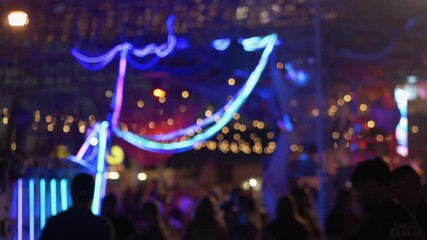 Colorful neon lights shaping dynamic night market moment, relaxed crowd and soft bokeh creating smooth festival vibe with calm movement and friendly outdoor energy. Neon lines glowing above crowd.  - Powered by Adobe