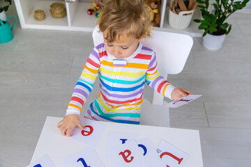The child learns English letters. Selective focus.