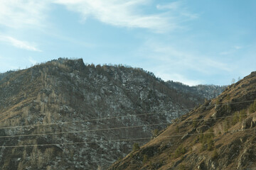 Mountain Slopes with Scattered Snow under Bright Sky