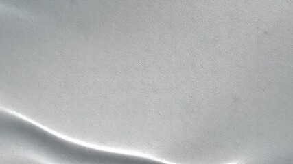 Close-up macro shot of smooth, light gray satin fabric texture with subtle waves and highlights - Powered by Adobe