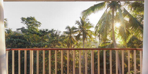 Obraz premium Sunlit Tropical Balcony With Jungle View And Coconut Palm Trees