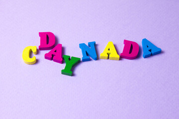 Canada Day wooden letters on purple background. Beautiful greeting card. Close-up. National holiday concept. Congratulations for family, relatives, friends and colleagues.