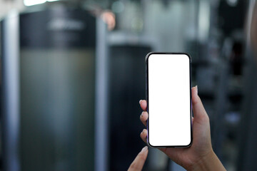 mockup hand holding a smartphone with transparent background with a gym blurred in the back