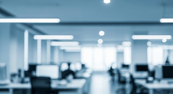 Blurry abstract shot of a modern office space with rows of computers and workstations, ideal for business and technology concepts