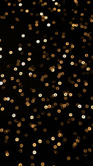 Shimmering gold sequins scattered on black background in abstract style for glamorous party and festive decoration