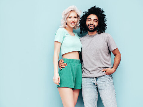 Smiling beautiful woman and her handsome boyfriend. Sexy cheerful multiracial family having tender moments on beige background in studio. Multiethnic models hugging. Embracing each other.Love concept - Powered by Adobe