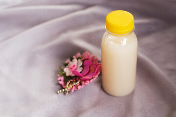 Bottle mockup and flowers on Soft Elegant Fabric backgound