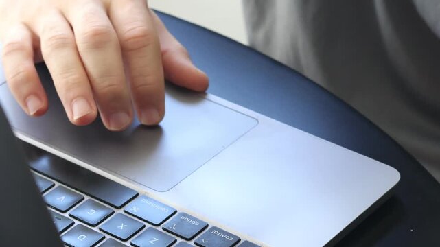 Close Up of Young Man Using Laptop Trackpad for Navigation