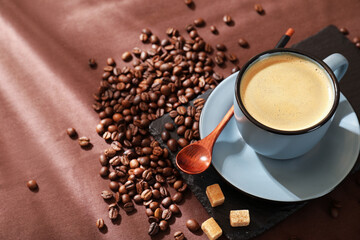 Aromatic coffee in cup, beans and brown sugar on table, above view. Space for text
