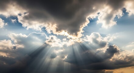 Stunning sun rays shining through dramatic clouds in the sky at sunrise