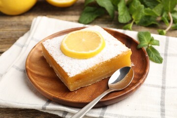 Tasty lemon bar with mint on wooden table, closeup