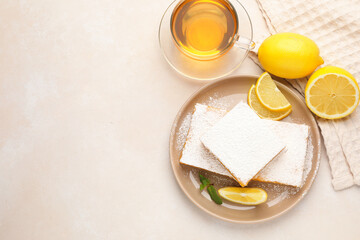 Tasty lemon bars with mint, fresh fruits and tea on beige table, flat lay. Space for text