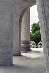 a view through a series of arches and stone pillars, The sunlight casts shadows on the...