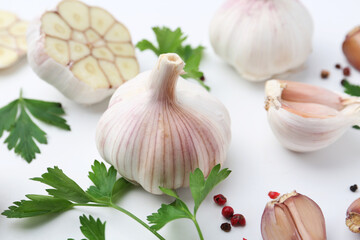 Garlic, peppercorns and parsley on white table, closeup