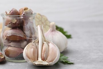 Garlic and parsley on light table, closeup. Space for text