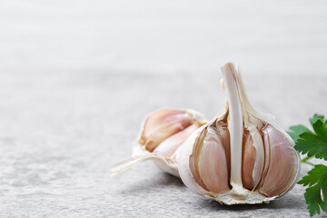 Garlic and parsley on light table, closeup. Space for text