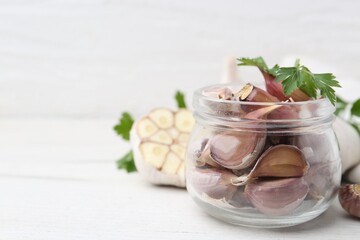 Garlic and parsley on white table, closeup. Space for text
