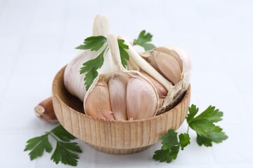 Garlic and parsley on white table, closeup