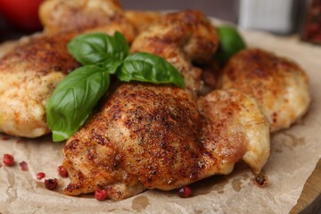Tasty roasted chicken thighs with on wooden board, closeup