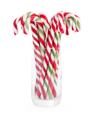 Obraz premium Tasty candy canes in glass isolated on white. Christmas treat