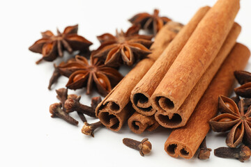 Mulled wine spices. Cinnamon sticks, anise stars and cloves on white wooden table, closeup