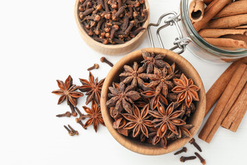 Different spices (anise, cinnamon, cloves) for mulled wine on white wooden table, flat lay