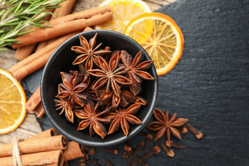 Different spices, fresh rosemary and dry orange slices for mulled wine on table, flat lay. Space for text