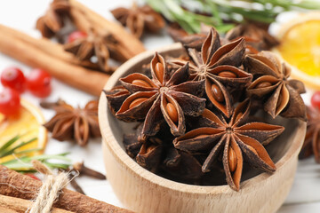 Different spices, dry orange slices, cranberries and fresh rosemary for mulled wine on light table, closeup