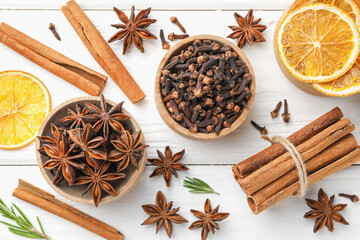 Different spices, dry orange slices and fresh rosemary for mulled wine on white wooden table, flat...