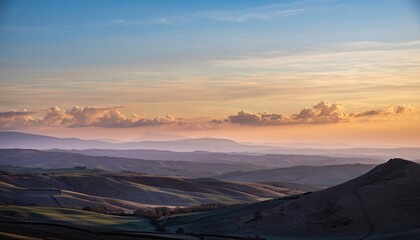 Hills And Valleys Under A Golden Sunrise Sky With Wispy Clouds In A Rural Landscape