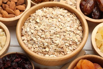 Making granola. Oat flakes, dried fruits and other ingredients on white wooden table, closeup