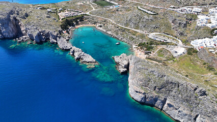 Obraz premium Aerial drone photo of elliptical shaped paradise bay and chapel of Saint Paul, featuring organized beach and crystal clear calm turquoise waters, Rhodes island, Dodecanese, Greece