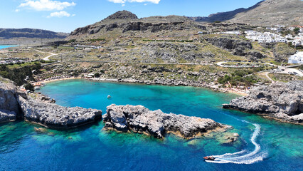 Aerial drone photo of elliptical shaped paradise bay and chapel of Saint Paul, featuring organized beach and crystal clear calm turquoise waters, Rhodes island, Dodecanese, Greece