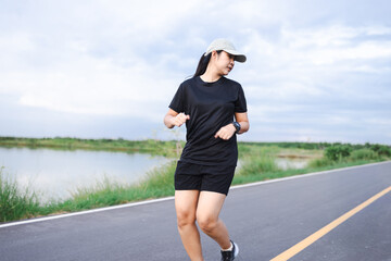 Beautiful Asian woman jogging in the evening,Portrait of Asian female runner jogging on street...
