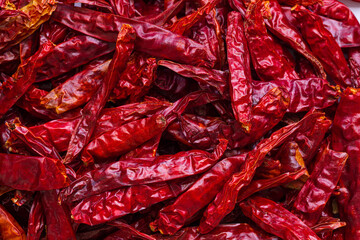 Close-up macro photography of dried chili peppers,Dry hot chillis for background,A close-up of a pile of dried red chili peppers, ideal for adding a touch of spice and color to culinary photography.