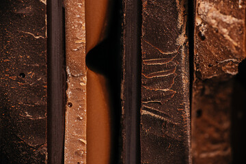 Close-up macro view of assorted chocolate bar edges with layered textures and rich tones, perfect...