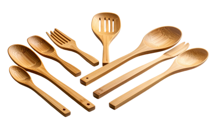 Assorted light brown wooden kitchen utensils on black background