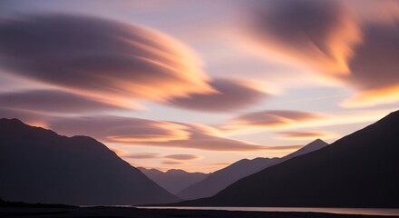 Dramatic Sunset Over Mountain Valley with Streaking Clouds.