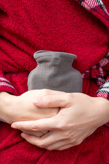 lady holding a small hot water bag on the stomach