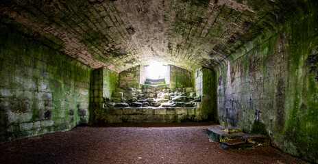 Ancient castle underground cellar of warkworth castle,, Northumberland. UK. Stone walls and cold, damp floor.