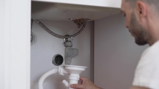 Plumber Tightens Loose Pipe Under Sink to Stop Water Leak