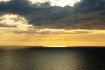 Aerial view of the coast at sunrise with clouds reflecting the sunlight on the sea, Santa Catarina, Brazil.